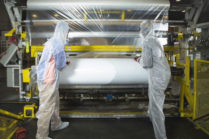 MBI Employees Running Laminator Machine