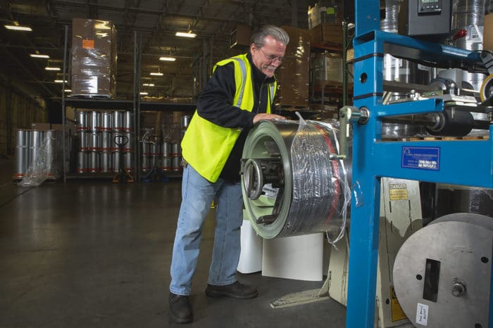 Employee Using Seamless Gutter Coil Machine